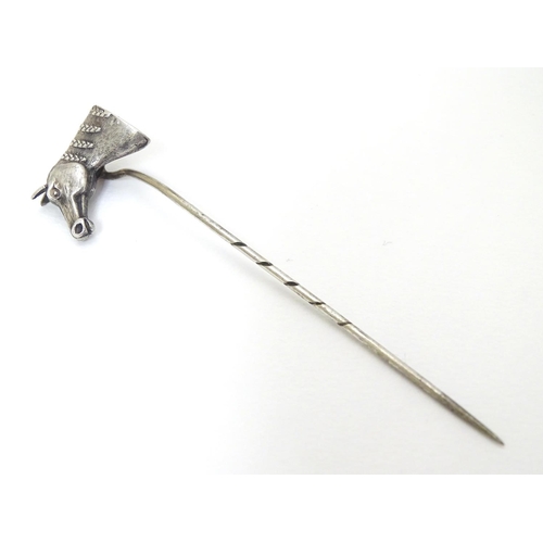 301 - A white metal stick pin surmounted by a horses head. Approx 3'' long overall