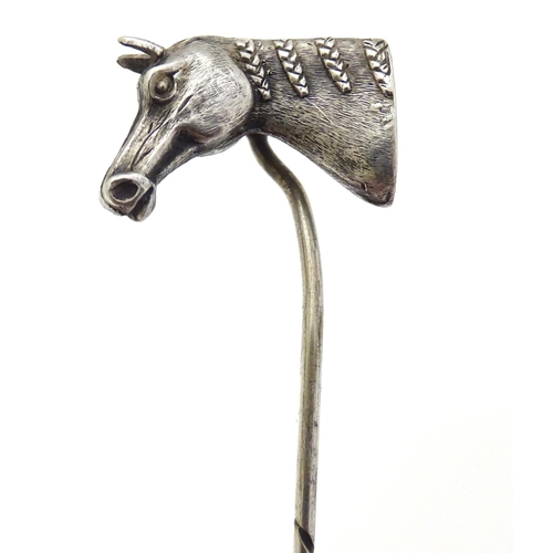 301 - A white metal stick pin surmounted by a horses head. Approx 3'' long overall