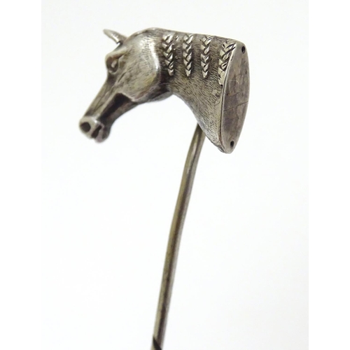 301 - A white metal stick pin surmounted by a horses head. Approx 3'' long overall