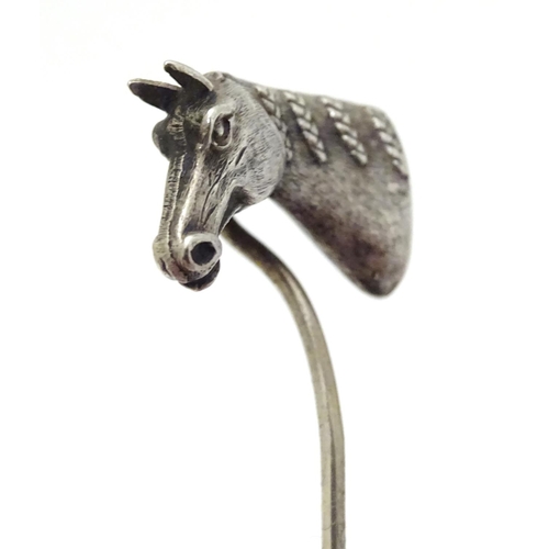 301 - A white metal stick pin surmounted by a horses head. Approx 3'' long overall