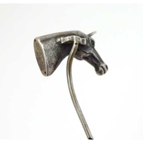 301 - A white metal stick pin surmounted by a horses head. Approx 3'' long overall