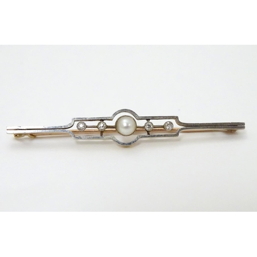 302 - An Art Deco gold brooch set with central pearl flanked by diamonds.   2 1/4'' wide