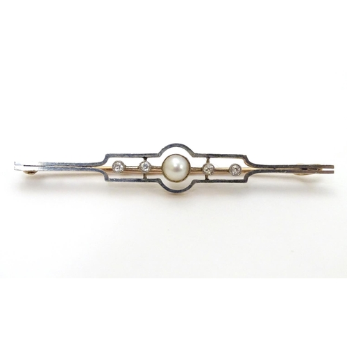 302 - An Art Deco gold brooch set with central pearl flanked by diamonds.   2 1/4'' wide