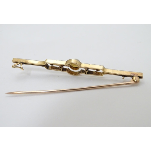 302 - An Art Deco gold brooch set with central pearl flanked by diamonds.   2 1/4'' wide