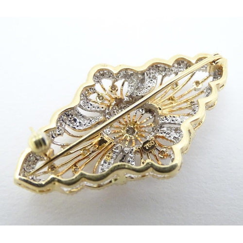 305 - A 18ct gold brooch set with a profusion of diamonds. 1 3/4'' wide