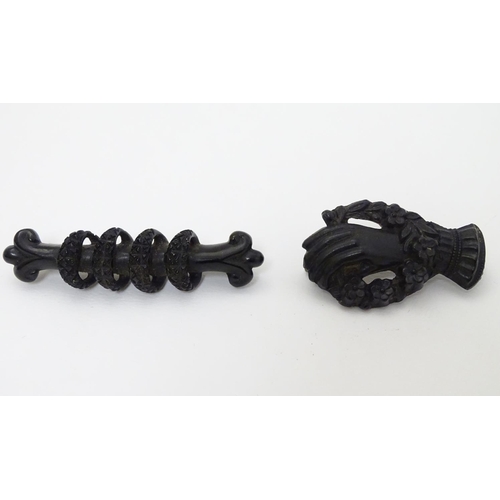 307 - Two Victorian Whitby jet brooches, one formed as a hand with flowers 1 ½'' long  . (2)