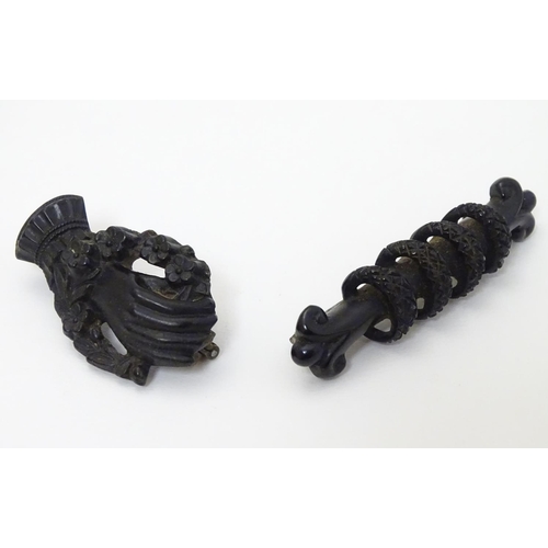 307 - Two Victorian Whitby jet brooches, one formed as a hand with flowers 1 ½'' long  . (2)