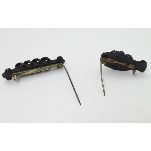 307 - Two Victorian Whitby jet brooches, one formed as a hand with flowers 1 ½'' long  . (2)