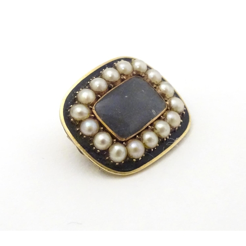 308 - A 19thC mourning brooch set with central lock of hair boarded by pearls and black enamel detail. The... 