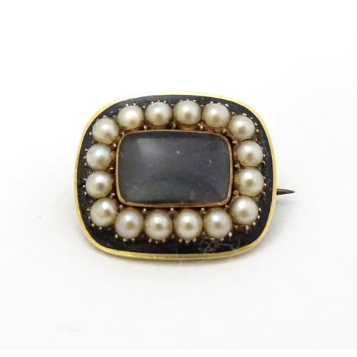 308 - A 19thC mourning brooch set with central lock of hair boarded by pearls and black enamel detail. The... 