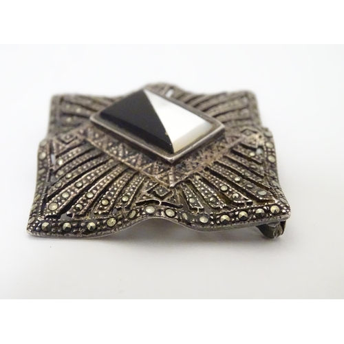 309 - A silver brooch set with a profusion of marcasite decoration and with  central black and mother of p... 