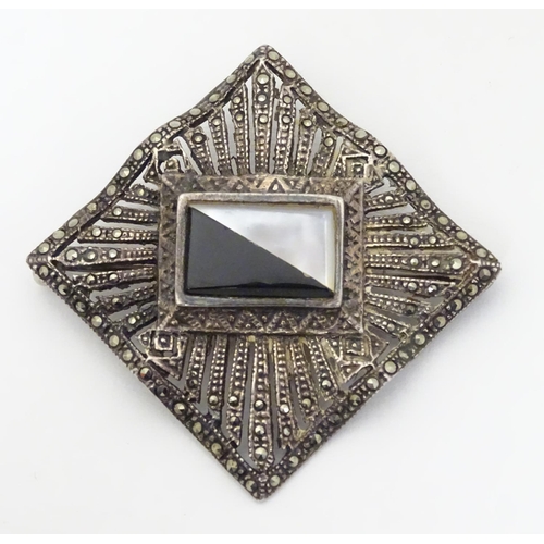 309 - A silver brooch set with a profusion of marcasite decoration and with  central black and mother of p... 