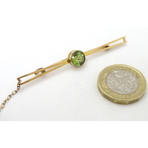 310 - A 9ct gold bar brooch set with central green stone, probably a green amethyst. 2 ½'' wide