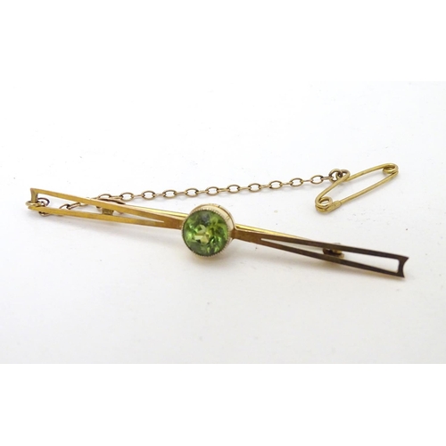 310 - A 9ct gold bar brooch set with central green stone, probably a green amethyst. 2 ½'' wide