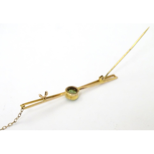 310 - A 9ct gold bar brooch set with central green stone, probably a green amethyst. 2 ½'' wide