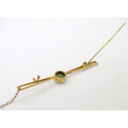 310 - A 9ct gold bar brooch set with central green stone, probably a green amethyst. 2 ½'' wide