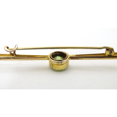 310 - A 9ct gold bar brooch set with central green stone, probably a green amethyst. 2 ½'' wide