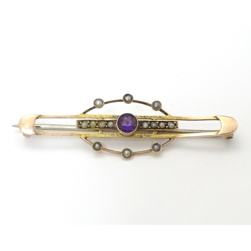 312 - A late 19thC / early 20thC 9ct gold brooch set with central amethyst and seed pearls. 1 3/4''