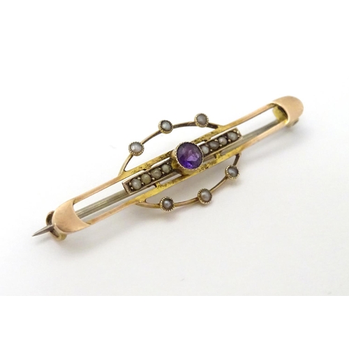 312 - A late 19thC / early 20thC 9ct gold brooch set with central amethyst and seed pearls. 1 3/4''