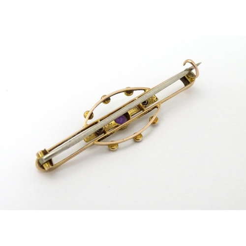 312 - A late 19thC / early 20thC 9ct gold brooch set with central amethyst and seed pearls. 1 3/4''