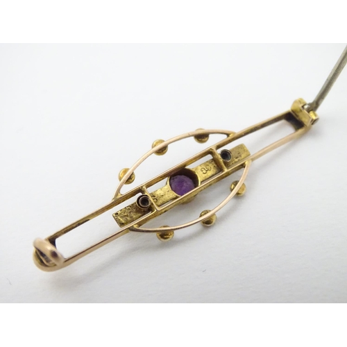 312 - A late 19thC / early 20thC 9ct gold brooch set with central amethyst and seed pearls. 1 3/4''