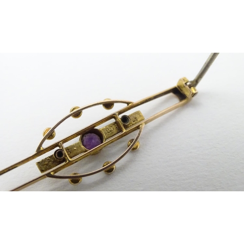 312 - A late 19thC / early 20thC 9ct gold brooch set with central amethyst and seed pearls. 1 3/4''