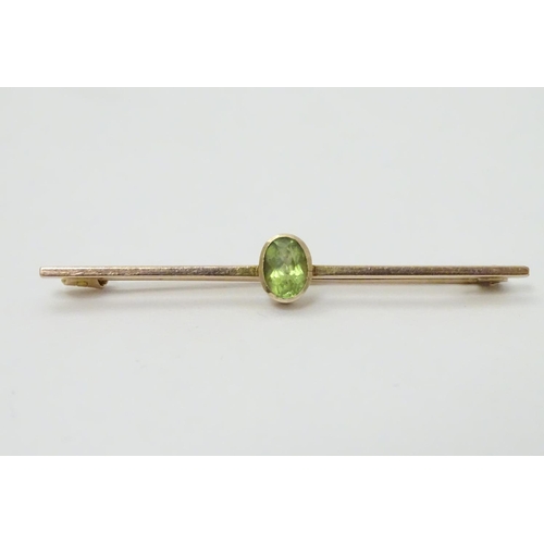 317 - A 9ct gold bar brooch set with oval peridot. 2'' long