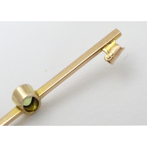 317 - A 9ct gold bar brooch set with oval peridot. 2'' long