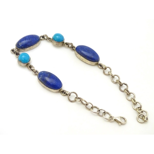 320 - A silver bracelet set with lapiz lazuli and turquoise cabochon.