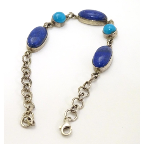 320 - A silver bracelet set with lapiz lazuli and turquoise cabochon.