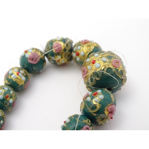 326 - 21 graduated Venetian glass beads with hand painted decoration. The largest approx ½'' diameter