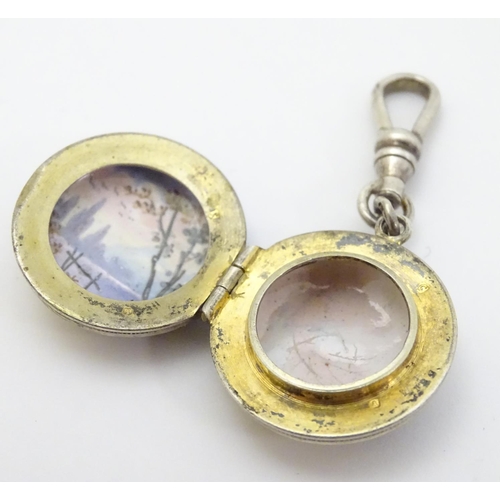 335 - A 19thC double sided locket with enamel decoration depicting figures in a landscape approx 7/8'' dia... 