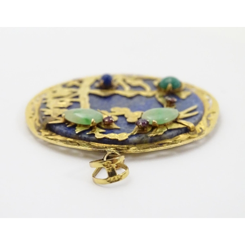 336 - An Oriental lapiz lazuli pendant set with jade, ruby, amethyst within a 14k gold mount. 1 3/4'' diam... 