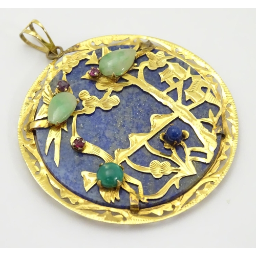 336 - An Oriental lapiz lazuli pendant set with jade, ruby, amethyst within a 14k gold mount. 1 3/4'' diam... 