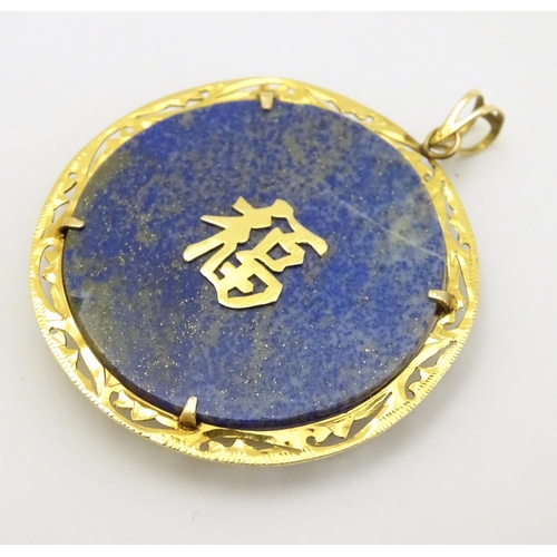 336 - An Oriental lapiz lazuli pendant set with jade, ruby, amethyst within a 14k gold mount. 1 3/4'' diam... 