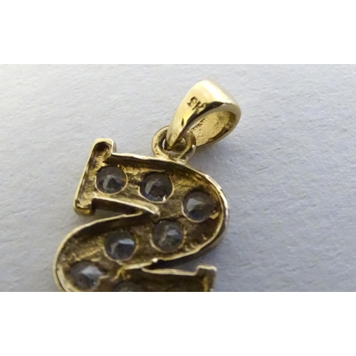 344 - A 9ct gold pendant  / charm formed as the letter 'S' and profusely set with white stones ½'' long