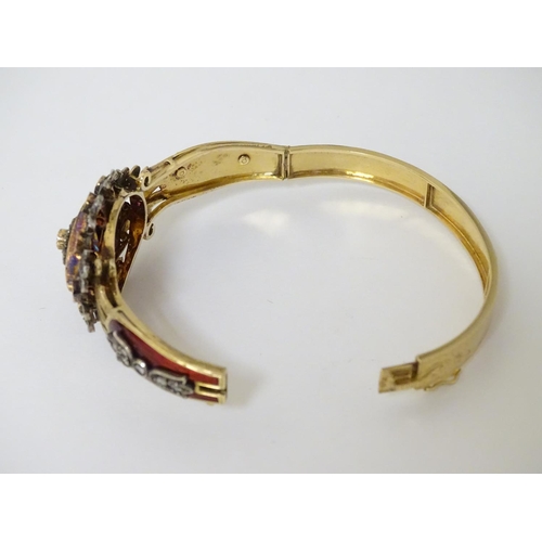 358 - A charming 18ct gold bangle bracelet set with diamonds and rubies and with red guilloché enamelling