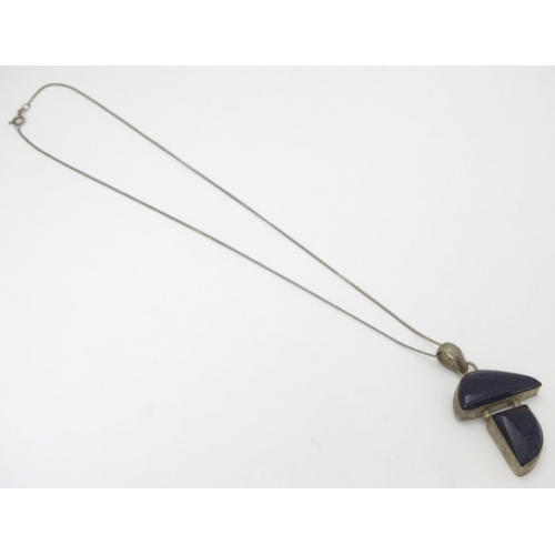 361 - A modernist pendant set with polished hardstone detail 2'' long with a 16'' silver chain.