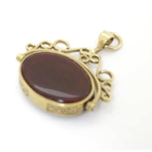 379 - A 9ct gold pendant fob with rotating green and carnelian central fob section. Approx 1 1/2'' long