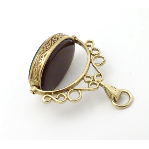 379 - A 9ct gold pendant fob with rotating green and carnelian central fob section. Approx 1 1/2'' long