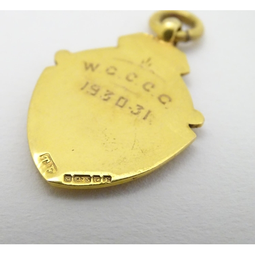 382 - A 9ct gold fob of shield form. approx 1 1/4'' long (4g)