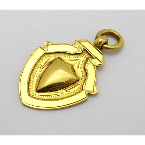 382 - A 9ct gold fob of shield form. approx 1 1/4'' long (4g)