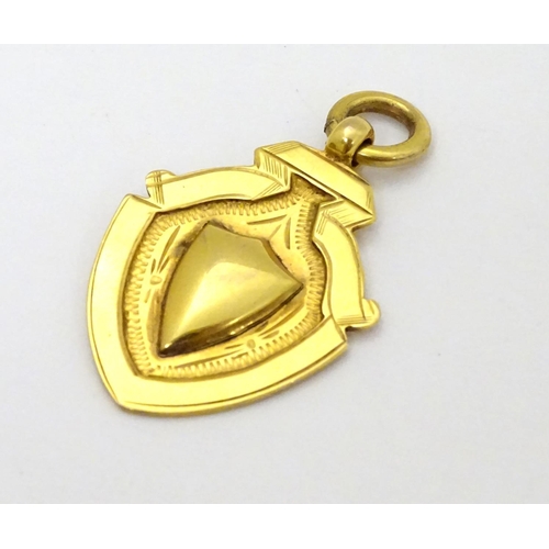 382 - A 9ct gold fob of shield form. approx 1 1/4'' long (4g)