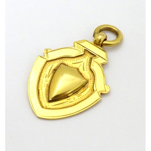 382 - A 9ct gold fob of shield form. approx 1 1/4'' long (4g)