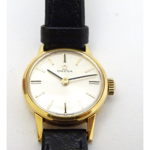 390 - Omega : a gold plate ladies mechanical wrist watch with champagne silvered signed dial, having an Om... 