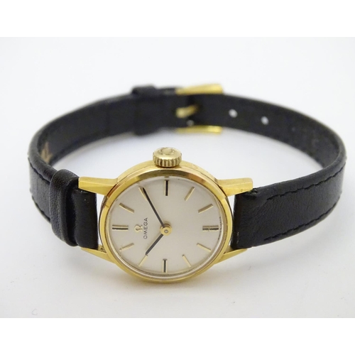 390 - Omega : a gold plate ladies mechanical wrist watch with champagne silvered signed dial, having an Om... 