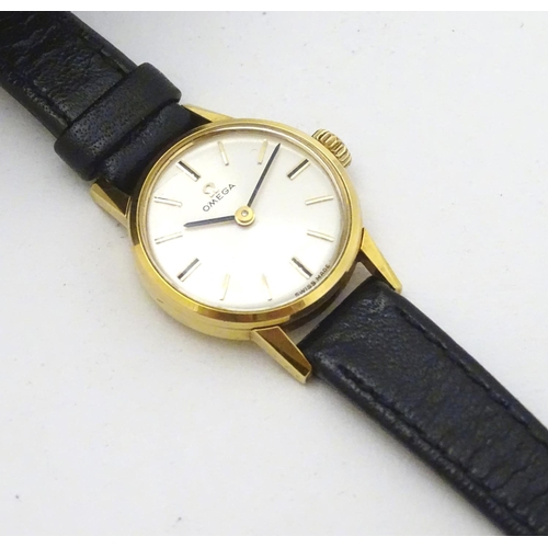 390 - Omega : a gold plate ladies mechanical wrist watch with champagne silvered signed dial, having an Om... 