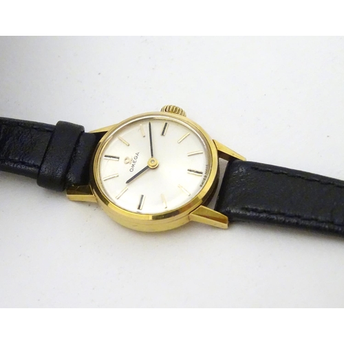 390 - Omega : a gold plate ladies mechanical wrist watch with champagne silvered signed dial, having an Om... 