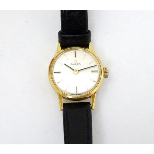 390 - Omega : a gold plate ladies mechanical wrist watch with champagne silvered signed dial, having an Om... 