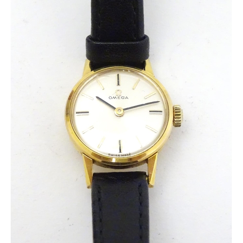 390 - Omega : a gold plate ladies mechanical wrist watch with champagne silvered signed dial, having an Om... 